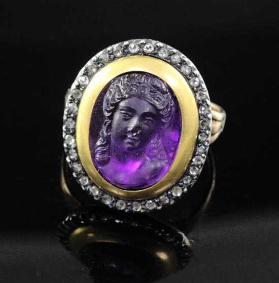 A 19th century amethyst glass? oval cameo ring, with rose cut diamond set border, (adapted?), size M.